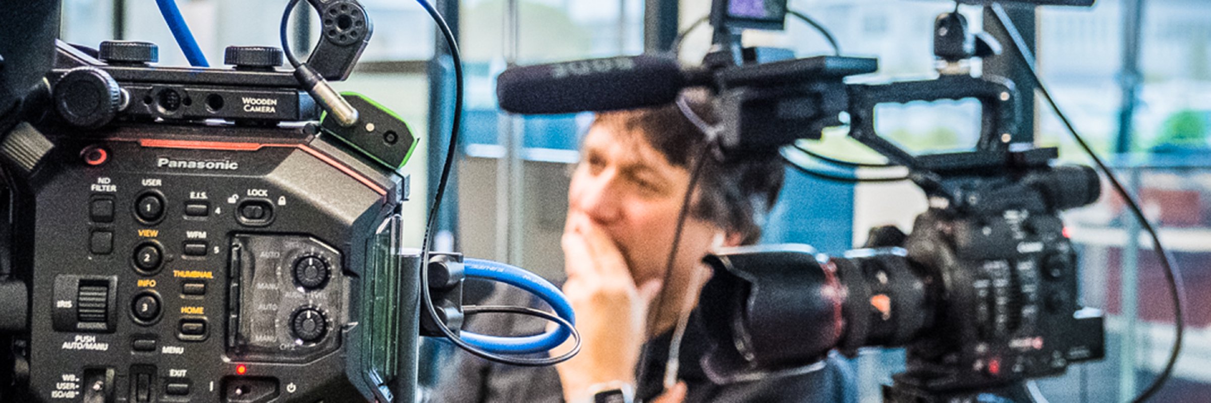 Jim visible in the background behind two video cameras